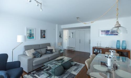 a living room with a couch and a table at Charming Apartment with Balcony & Pool in Lisbon
