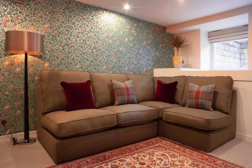 a living room with a brown couch in a room at The Roseate Edinburgh - Small Luxury Hotels of the World in Edinburgh