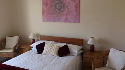 sypialnia z łóżkiem i fioletowym obrazem na ścianie w obiekcie Trenwith w mieście Perranporth