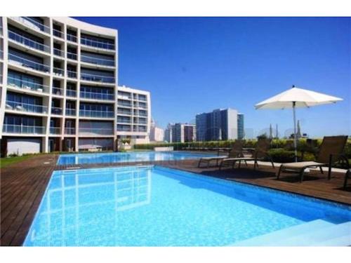 a swimming pool in front of a large building at Charming Apartment with Balcony & Pool in Lisbon