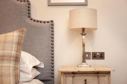 a lamp on a night stand next to a bed at The Roseate Edinburgh - Small Luxury Hotels of the World in Edinburgh