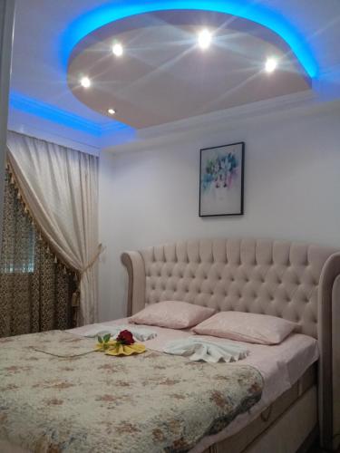 a bedroom with a large bed with a blue light at Apartman Tea 2 in Banja Luka
