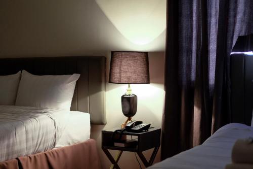 a hotel room with a bed and a lamp and a phone at CREVICE HOTEL in Davao City