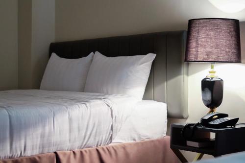 a bedroom with a bed with a lamp and a phone at CREVICE HOTEL in Davao City