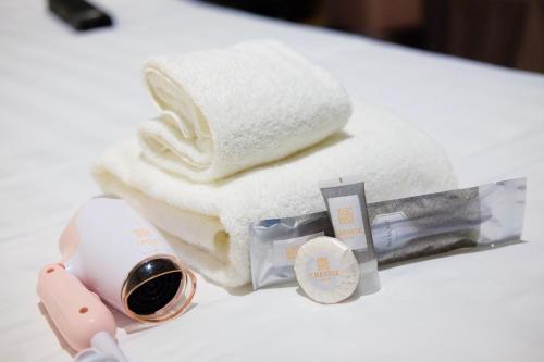 a pile of towels and a bottle of wine on a table at CREVICE HOTEL in Davao City