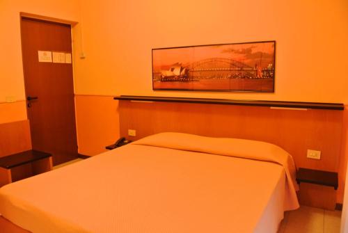 a bedroom with a bed and a picture on the wall at Giardino Hotel in Milan