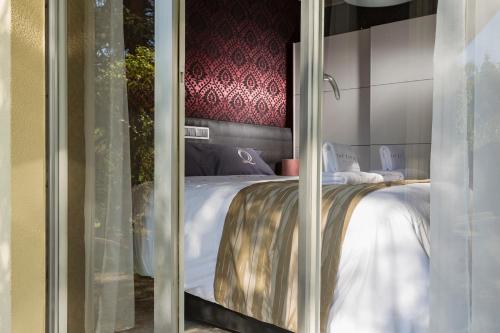 1 dormitorio con cama blanca y pared roja en Villa Canterbury en Luxemburgo