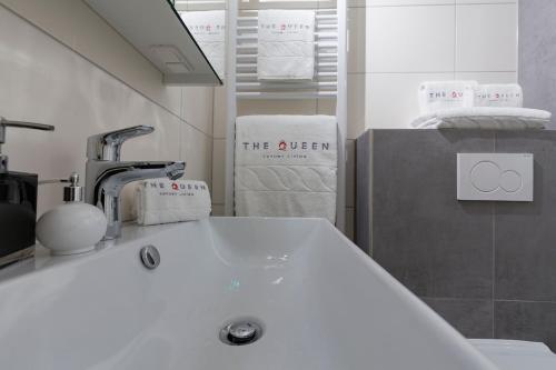 a bathroom with a white sink and towels at Villa Canterbury in Luxembourg