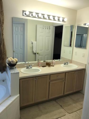a bathroom with two sinks and a large mirror at Robin's Nest in Orlando