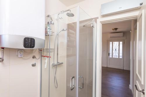 a bathroom with a shower with a glass door at Adorma Hum in Hum