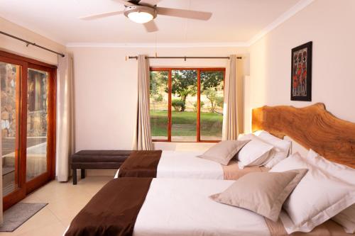 a bedroom with two beds and a window at Sangasava Safari Lodge in Balule Game Reserve