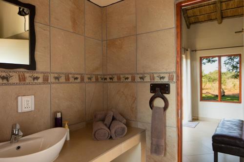 a bathroom with a tub and a sink and a mirror at Sangasava Safari Lodge in Balule Game Reserve