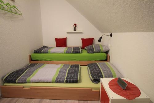 two beds in a room with green and red at Ferienhaus**** Wind und Wolke in Friedrichskoog-Spitz