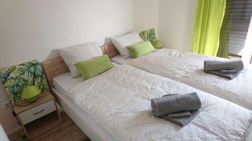 2 camas en un dormitorio con almohadas verdes. en Ela Cres, en Cres
