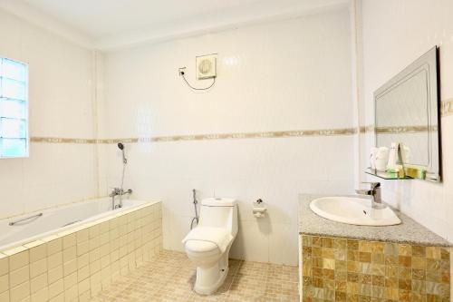 un bagno bianco con un water e un lavandino di K.C Residence a Yangon