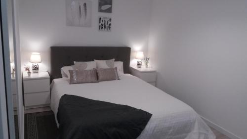a bedroom with a large white bed with two night stands at Sunset House Azores in Ponta Delgada