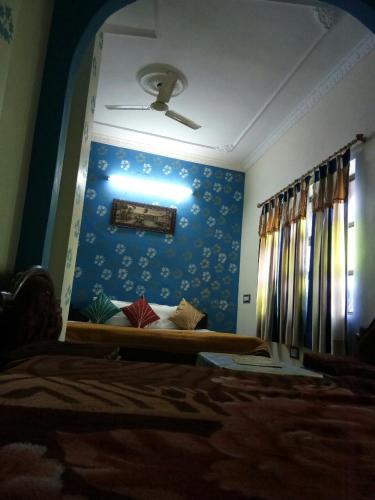 a bedroom with a bed and a blue wall at Haveli Taragarh Palace in Būndi