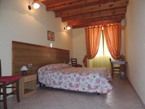 a bedroom with a bed and a desk and a window at La marina in Cagliari