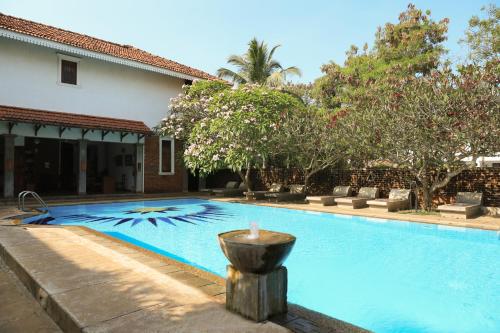 a swimming pool with a fountain in front of a house at Villa Araliya in Negombo