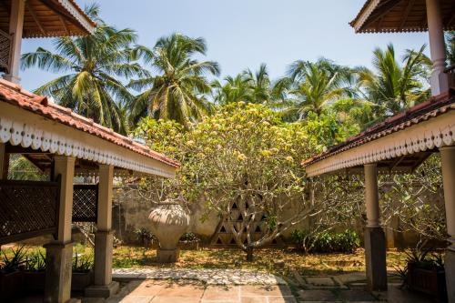 a courtyard of a house with palm trees in the background at Villa Araliya in Negombo