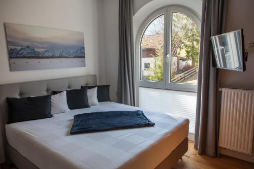 a bed in a bedroom with a large window at Chalet-Pfronten in Pfronten