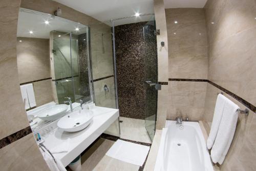 a bathroom with a tub and a sink and a shower at Ayan Hotel in Riyadh
