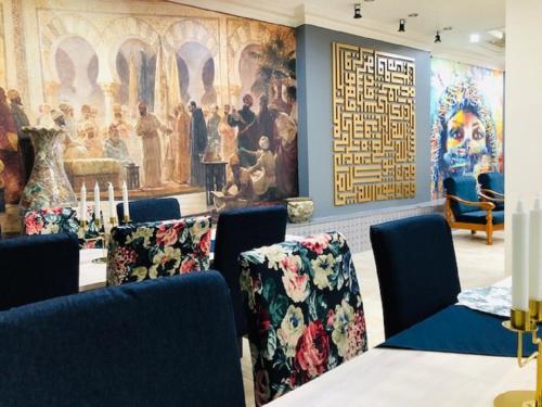 a room with chairs and a large painting on the wall at Arabesque Hotel in Amman