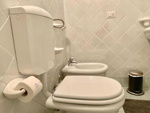 a bathroom with a white toilet and a sink at Casa Panke in Scicli