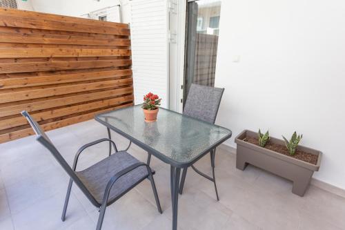 a glass table and two chairs on a patio at Cloud 3 Apartment in Kalamata