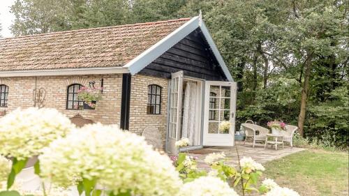 a small brick house with a white door at Bed & Breakfast de Appelaar in Rijs