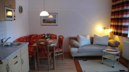 a kitchen and living room with a couch and a table at Haus Schönblick in Bach