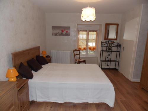 a bedroom with a large white bed in a room at GITE DES ROCHES in La Roche-Vanneau