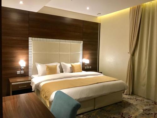 a bedroom with a large bed with a large headboard at Ayan Hotel in Riyadh