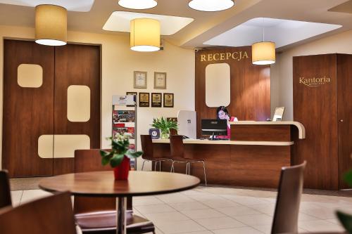 a lobby of a hospital with a reception desk and tables at Hotel Kantoria in Tarnów