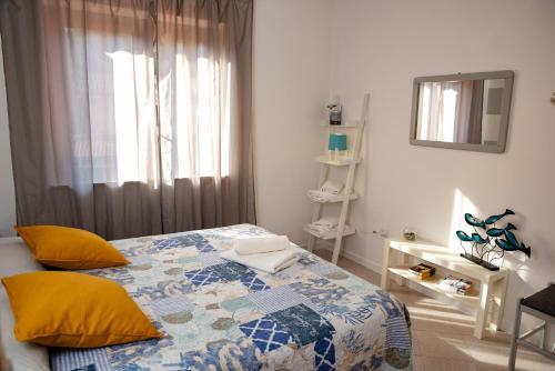 a bedroom with a bed with yellow pillows and a window at Le Ville di Porto Ada in Pizzo