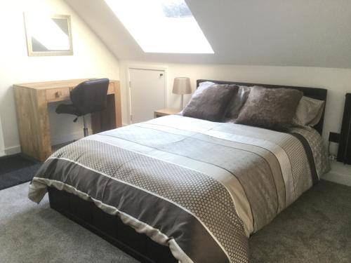 a bedroom with a bed and a desk and a chair at Idyllic Studio Flat in Winchester