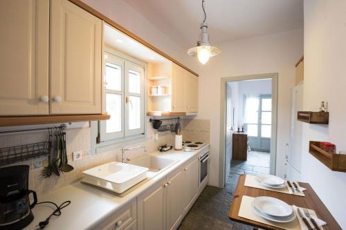 a kitchen with white cabinets and a sink at Villa Filitsa in Platis Gialos