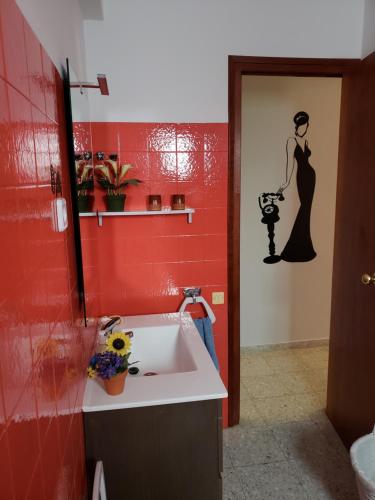 baño con lavabo y pared roja en Can Cristina, en Aldover
