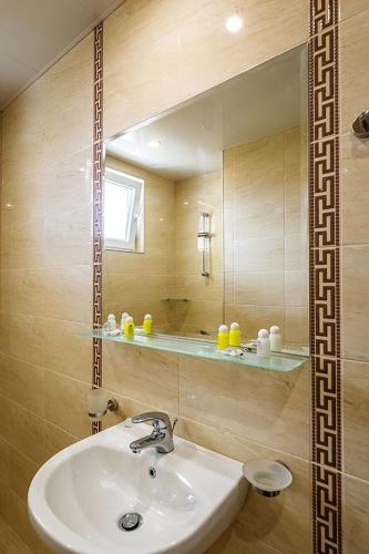 a bathroom with a sink and a mirror at Family Hotel Bulgaria in Kharmanli