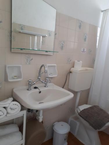 a bathroom with a sink and a toilet and a mirror at Sophie Studios in Roda