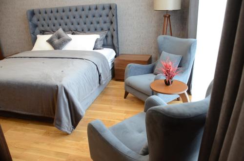 伊斯坦堡的住宿－Teknosports Otel，一间卧室配有一张床、两把椅子和一张桌子