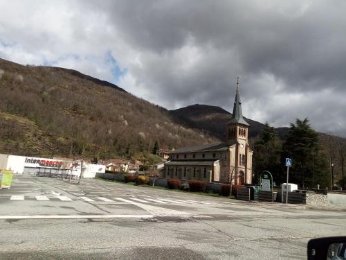 a church with a steeple on the side of a street at SAVIGNAC in Savignac-les-Ormeaux