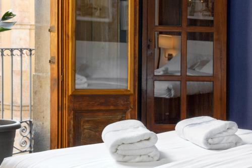dos toallas sentadas encima de una cama en Hostal Sol y K, en Barcelona