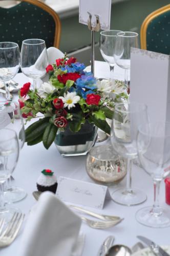 a table with glasses and a vase of flowers on it at Cashel House Hotel in Roundstone