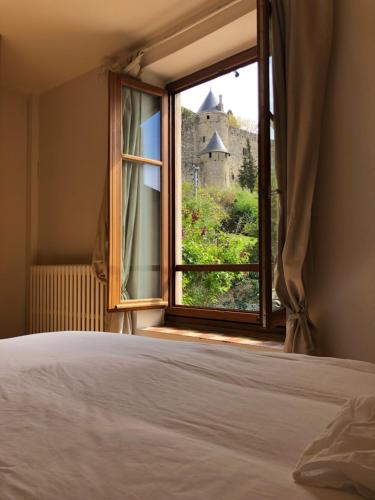 - une chambre avec une fenêtre donnant sur un château dans l'établissement Côte de la Cité, à Carcassonne