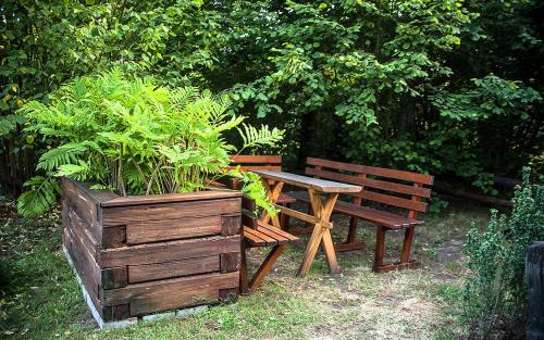 a wooden table and bench next to a potted plant at Grenlanda in Ulanów