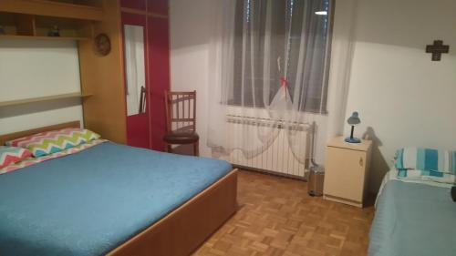 a bedroom with two beds and a window and a chair at Apartman Dino in Roč