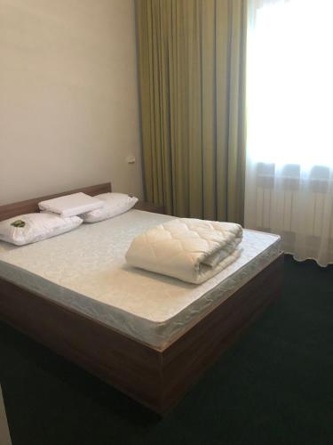 2 colchones en una cama en una habitación con ventana en Motel “Satti” en Shetpe