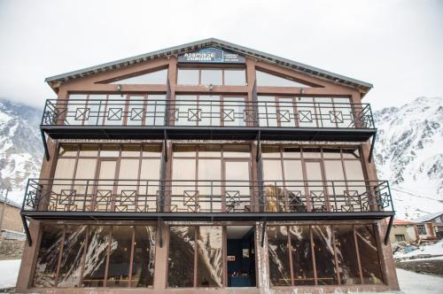 a building with a balcony on top of it at Chemodann Kazbegi in Stepantsminda