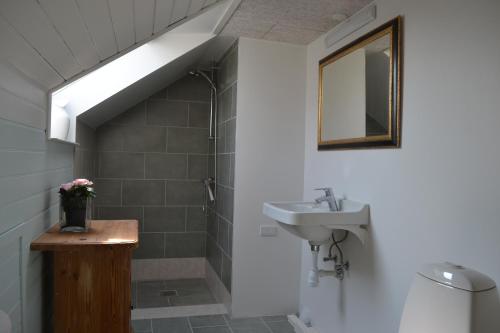 a bathroom with a sink and a mirror at Tante Tut & Onkel E - B & B - Hotel in Kolby Kås